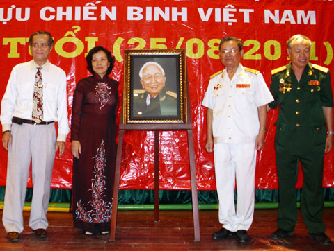 Đại tá Hoàng Minh Phương (thứ hai từ bên phải qua) trao bức "Hào khí trăm năm" do nghệ nhân Ý Lan gửi tặng cho Đại tướng